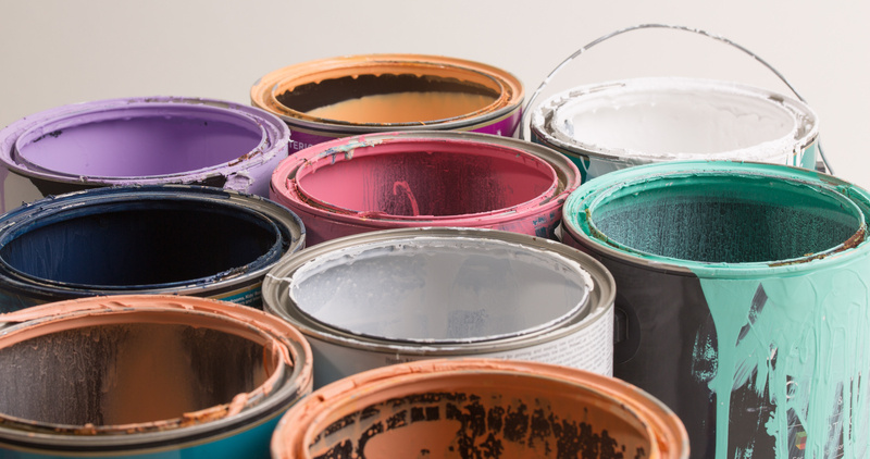 Multi-colored paint cans all opened.